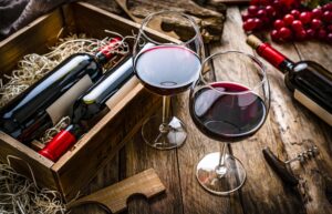 Two red wineglasses on rustic wooden table